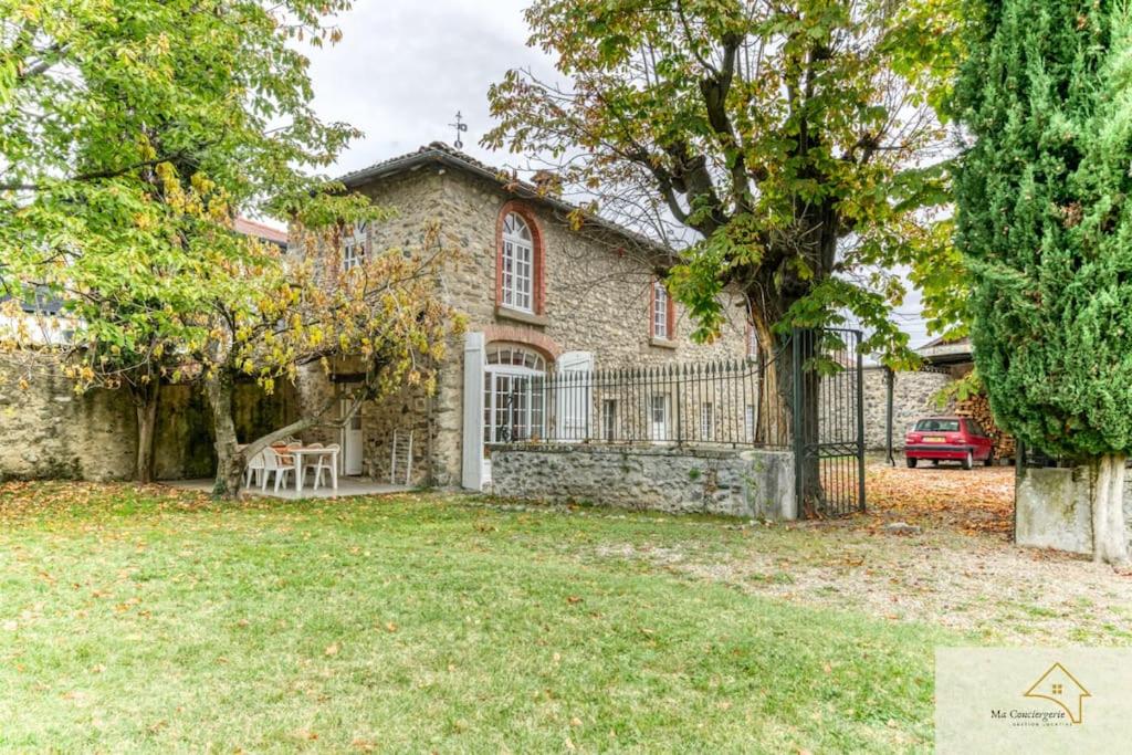 a stone house with a gate and a yard at Le Charme Antique¶ Belle maison¶ Centre Gières in Gières