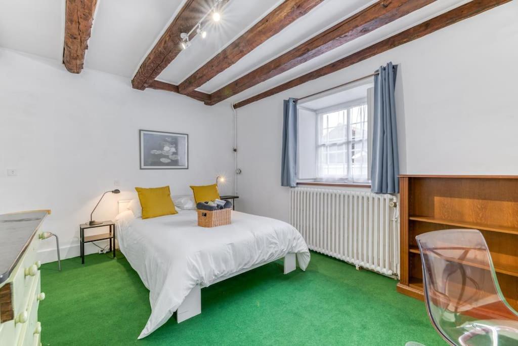 a bedroom with a white bed and a green floor at Le Charme Antique¶ Belle maison¶ Centre Gières in Gières