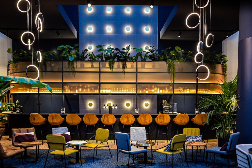 un restaurant avec des tables, des chaises et des plantes dans l'établissement Mercure Antwerp City South, à Anvers