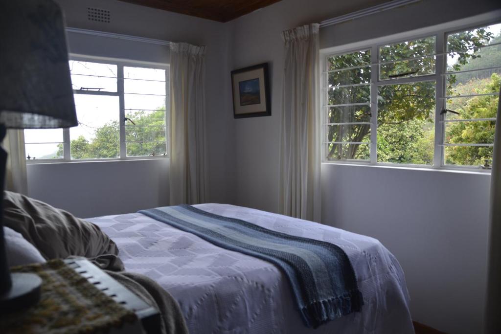 a bedroom with a bed and two windows at Bezalel's Rest in Sabie