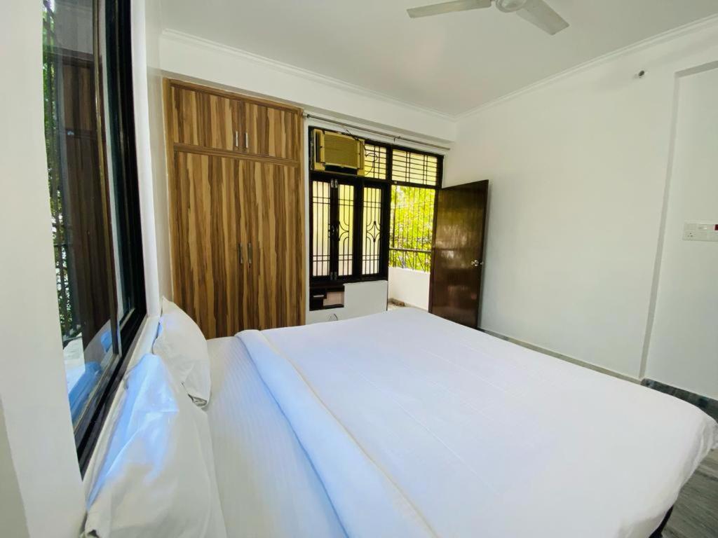 a bedroom with a white bed and a window at The white yard stays in Varanasi