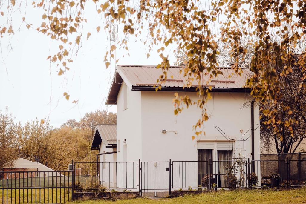 ein weißes Haus mit einem Zaun davor in der Unterkunft Weekend Joy Home in Visoko