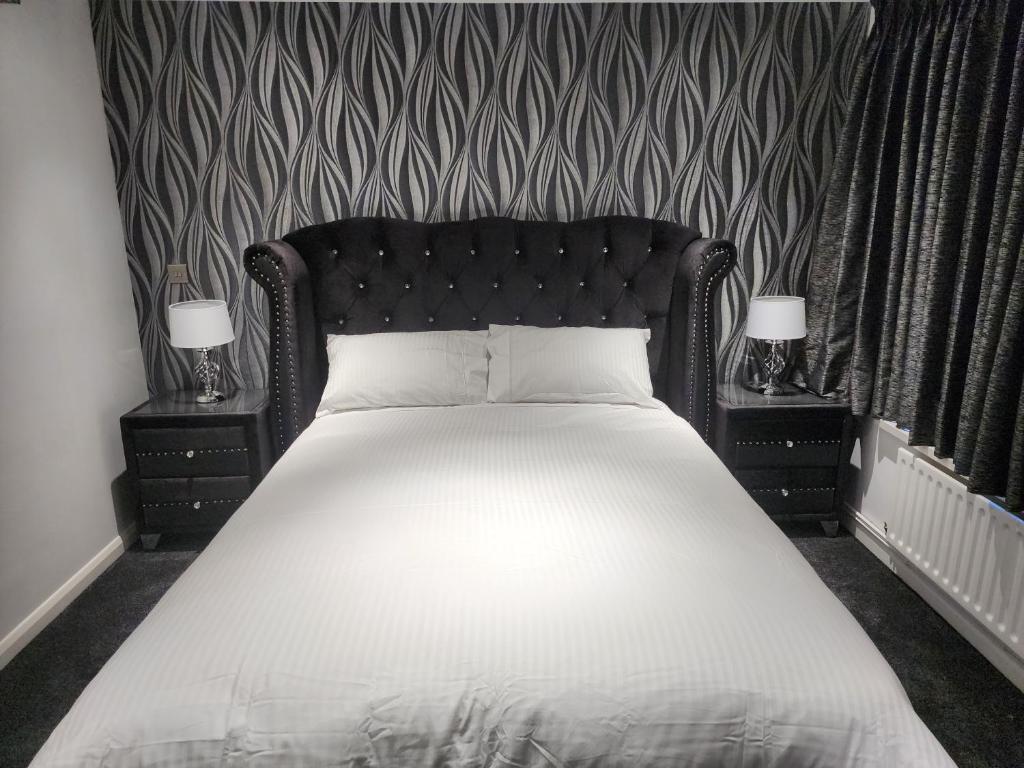 een slaapkamer met een groot bed met 2 nachtkastjes bij Belfast Luxury Apartment in Belfast