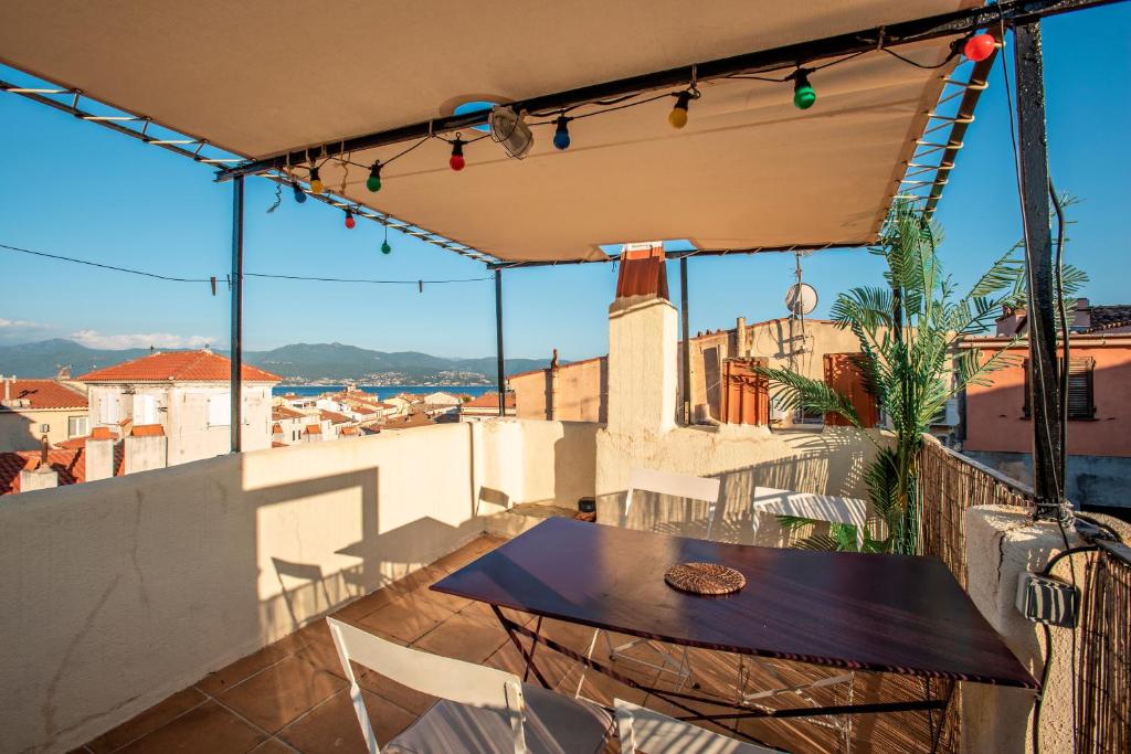 een patio met een tafel en stoelen op een dak bij Toit Terrasse centre historique in Ajaccio