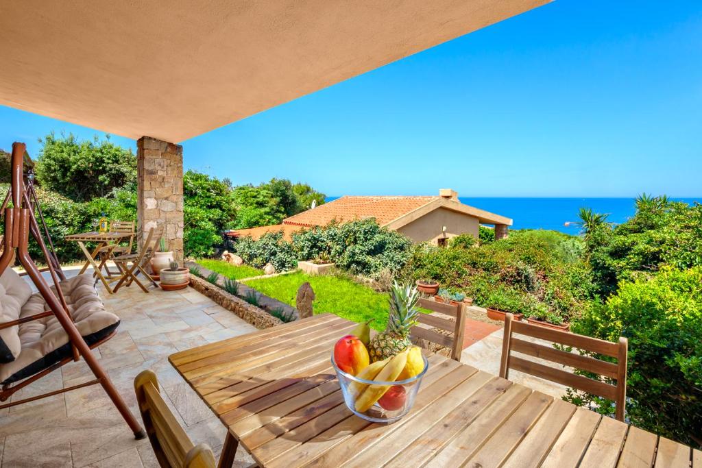 a bowl of fruit on a wooden table on a patio at Villa Giorgia - Costa Paradiso in Costa Paradiso