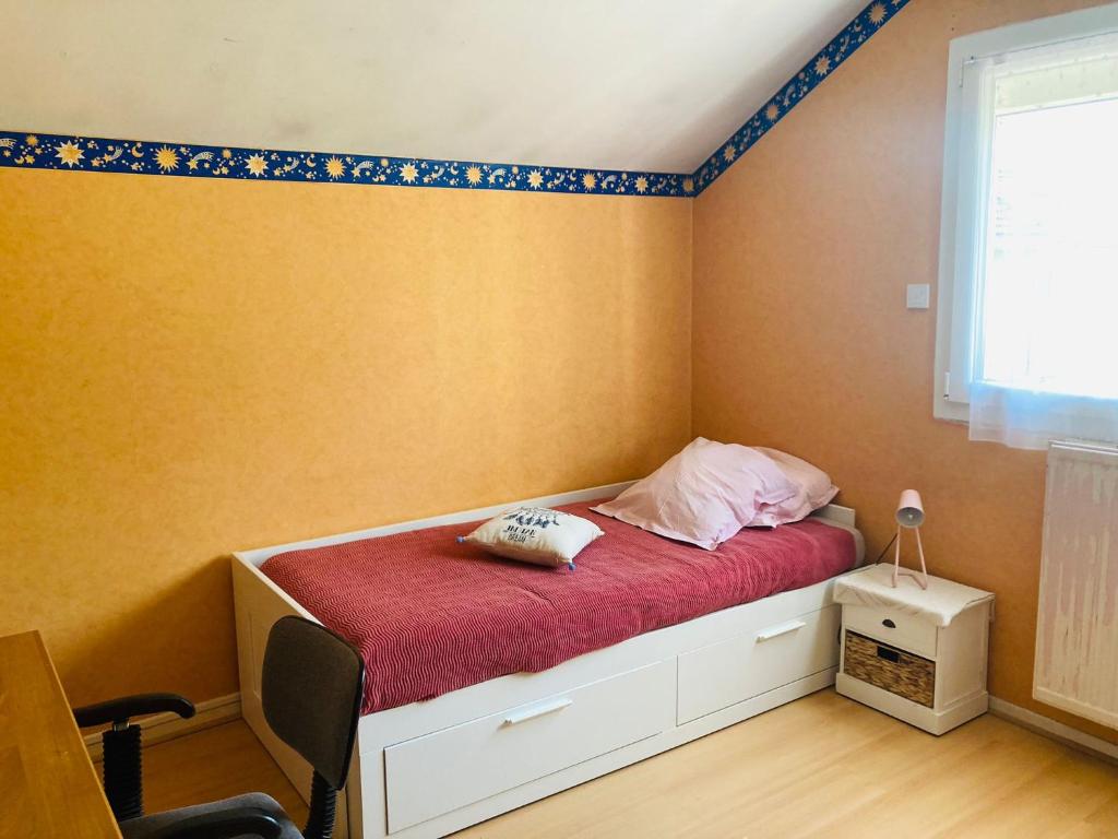 1 dormitorio pequeño con 1 cama con manta roja en Chambre chez l'habitant. en Metz