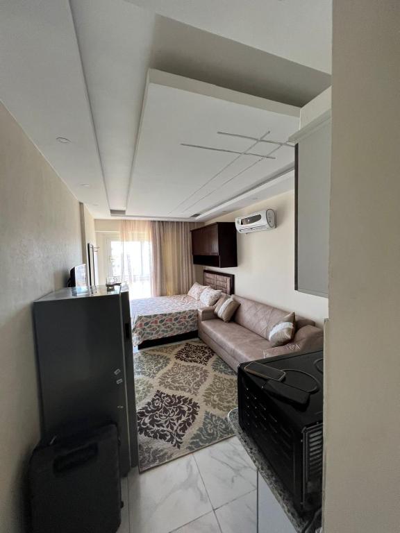 uma sala de estar com um sofá e uma televisão em zooz home vacation em El Alamein