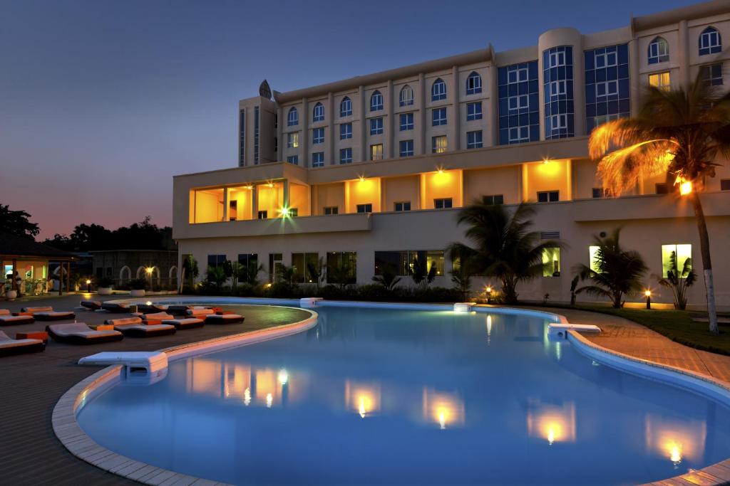 un hôtel avec une grande piscine la nuit dans l'établissement Azalaï Hôtel Cotonou, à Cotonou