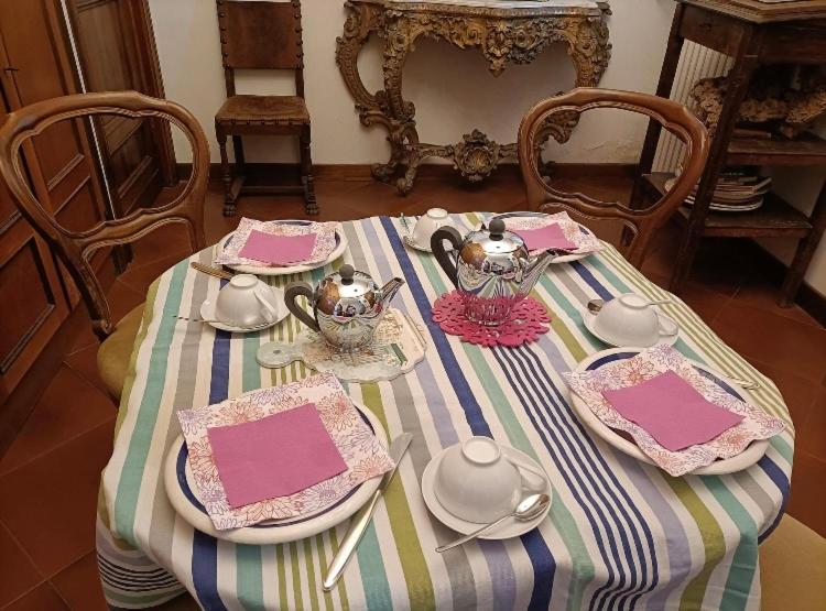 einen Tisch mit Tellern und Teezubehör in der Unterkunft Lupo Azzurro in Siena
