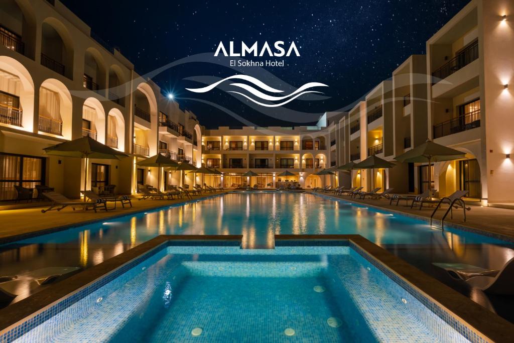 ein Schwimmbad in der Mitte eines Gebäudes in der Nacht in der Unterkunft Al Masa Hotel El Sokhna in Ain Suchna
