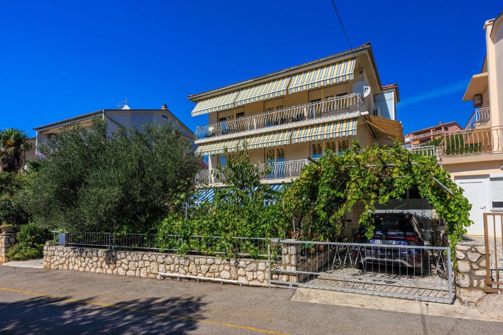 an apartment building with a stone wall and trees at Apartments Antonio in Crikvenica