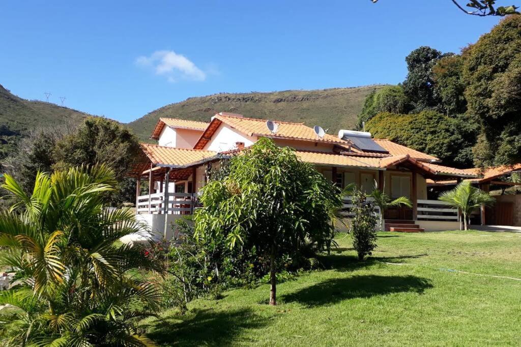 a house with a green yard in front of it at Sítio da Serra em Ouro Preto MG in Cachoeira do Campo