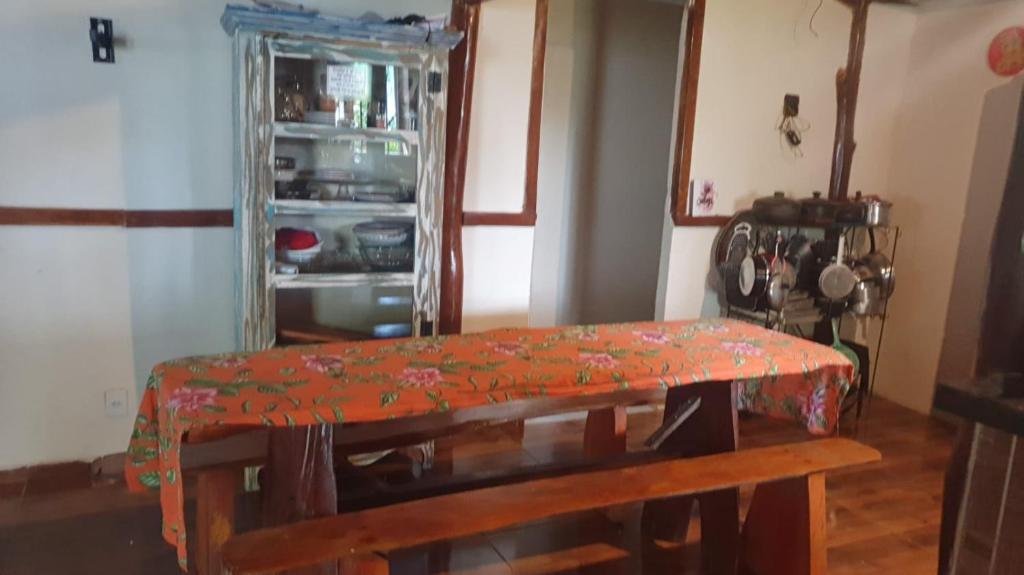 a room with a table and a refrigerator at SITIO RECANTO DOS PASSAROS in Itacaré