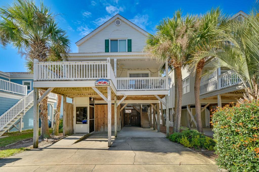 a house with palm trees in front of it at Surfside Beach Oasis with Private Pool and Gas Grill! in Myrtle Beach