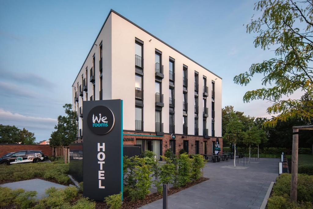 un bâtiment avec un panneau devant lui dans l'établissement We rooms Hotel, à Karben