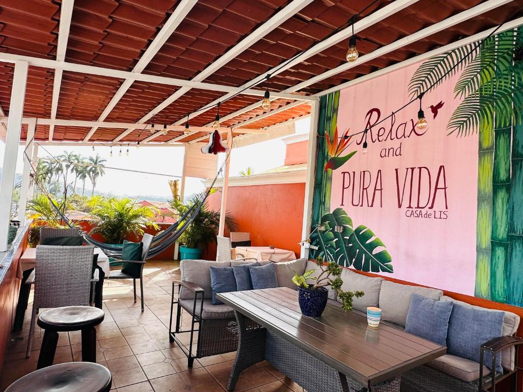 un restaurante con mesas y sillas y un cartel en la pared en Casa de Lis Hotel & Tourist Info Centre, en Turrialba