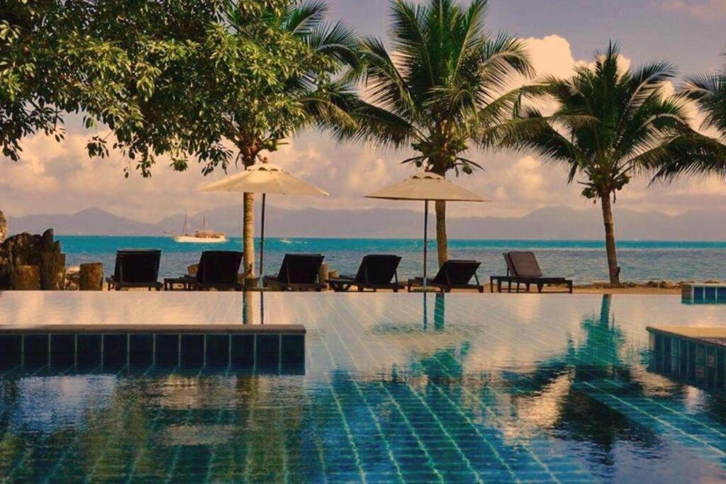 uma piscina com cadeiras e guarda-sóis e o oceano em 2 Bedroom Beachfront Villa Bang Po (B1) SDV098 By Samui Dream Villas em Koh Samui