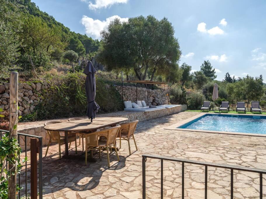 a patio with a table and chairs next to a pool at Preciosa casa familiar cerca Esporlas Na Servera in Esporles