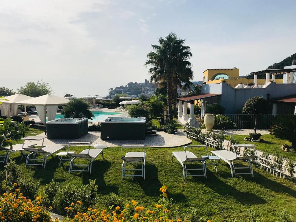 eine Gruppe von Stühlen und Sonnenschirmen neben einem Pool in der Unterkunft Hotel Bougainville in Lipari