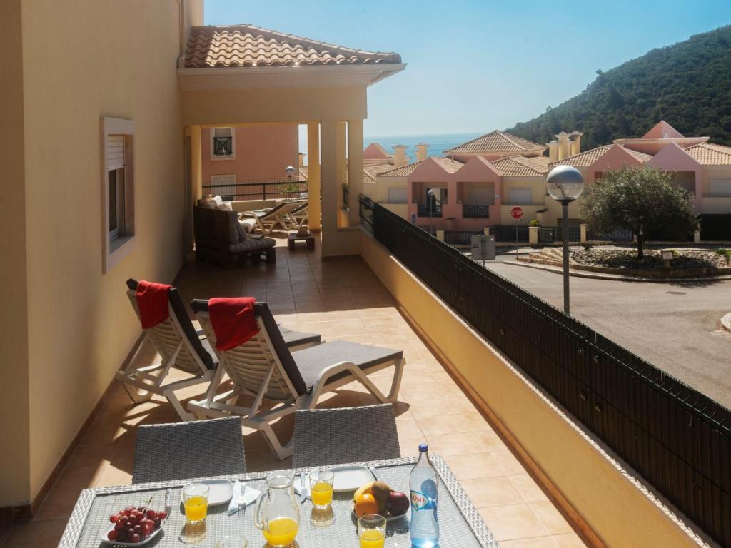 a balcony with two chairs and a table with drinks on it at Holiday Home O segredo de Sesimbra by Interhome in Sesimbra