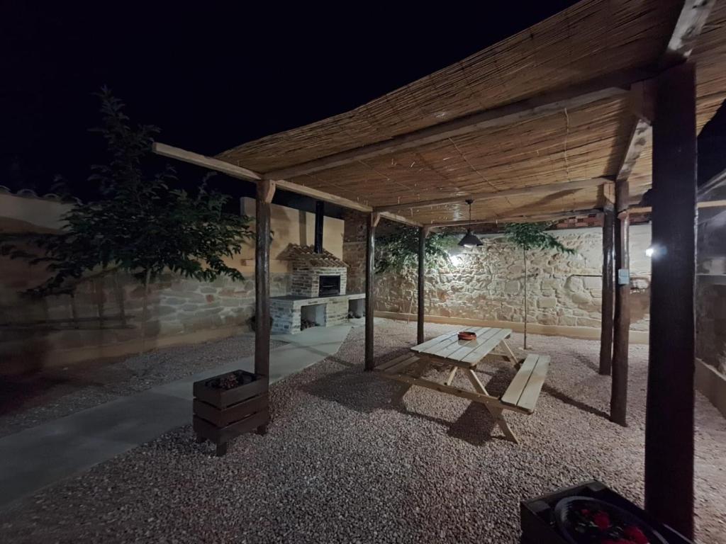a wooden pavilion with a picnic table and a stove at Casa Rural Claudia in Puigmoreno