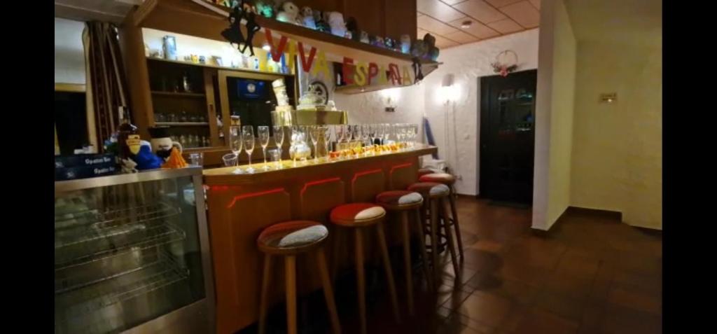 een bar met een rij krukken in een kamer bij Frankenstube-Winkelhaid in Winkelhaid