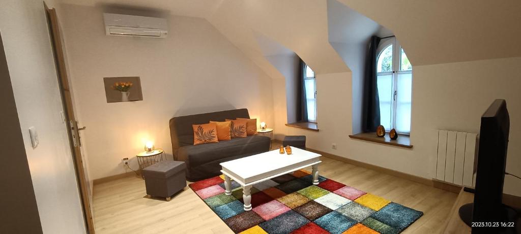 een woonkamer met een bank en een tafel bij Gîte VILLA ESPERANZA (2-6 personnes) in Valençay