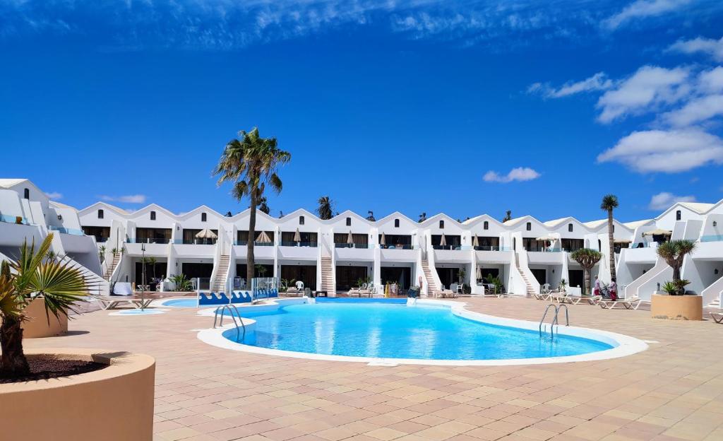 een resort met een zwembad en een gebouw bij Sands Beach - Hoy Hotels in Costa Teguise