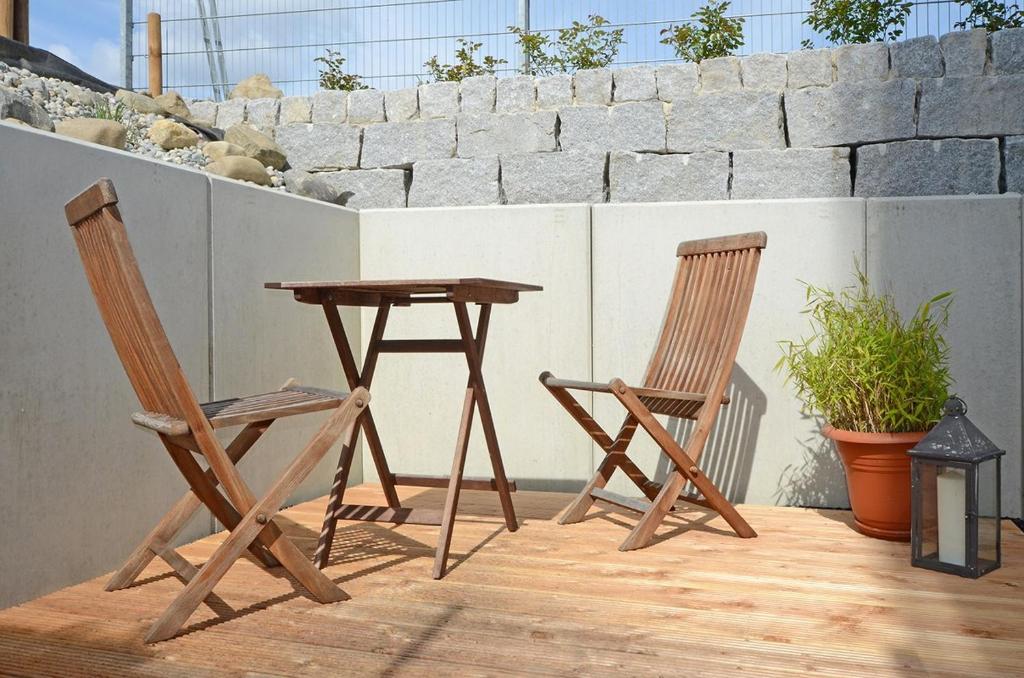 2 Holzstühle und ein Tisch auf der Terrasse in der Unterkunft Ecker in Überlingen