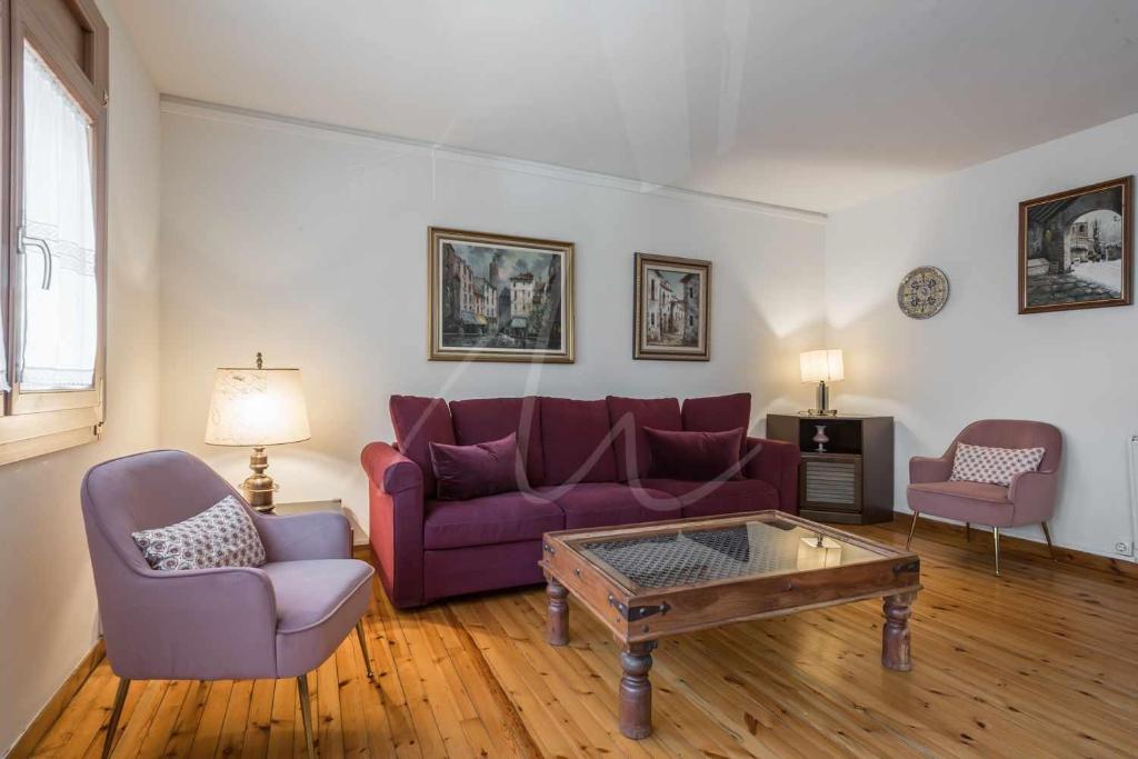 Sala de estar con sofá púrpura y mesa de centro en Era Puma by SeaMount Rentals, en Vielha