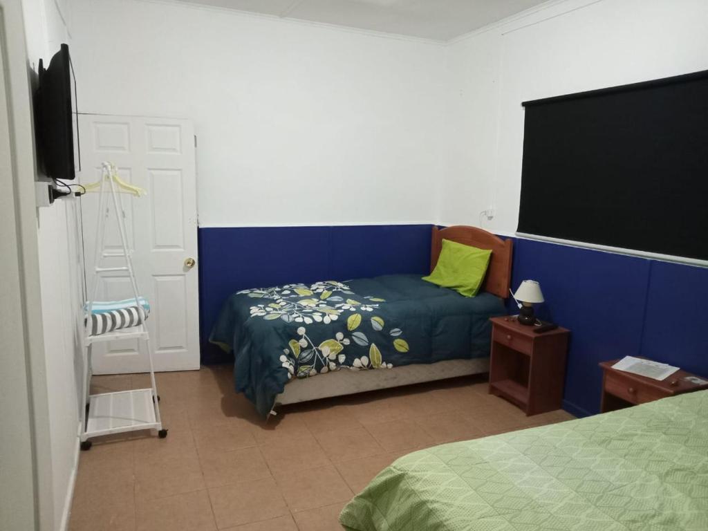 a bedroom with a bed and a tv and a chair at POSADA COPACABANA in Tocopilla