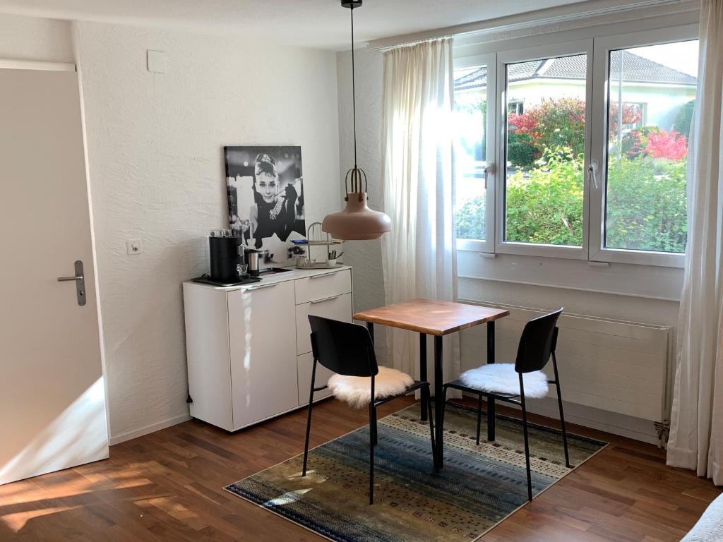 uma cozinha com mesa e cadeiras num quarto em B&B Biel-Brügg em Brügg