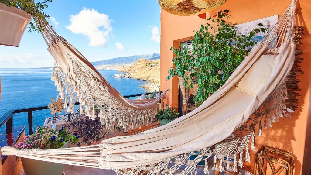 een hangmat hangend aan een gebouw met uitzicht op de oceaan bij Luxury House Direct To The Beach & Natural Salt Pool in Tabaiba
