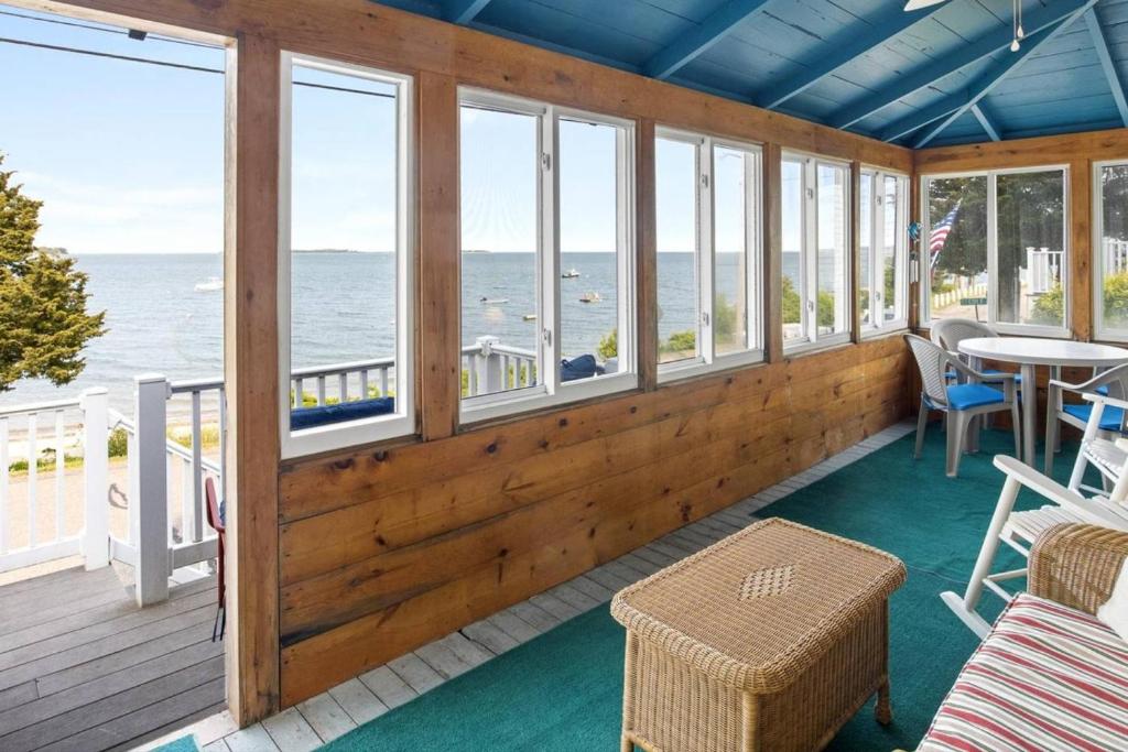 a screened in porch with a view of the ocean at Clara's Retreat: Rocky Nook Kingston in Kingston