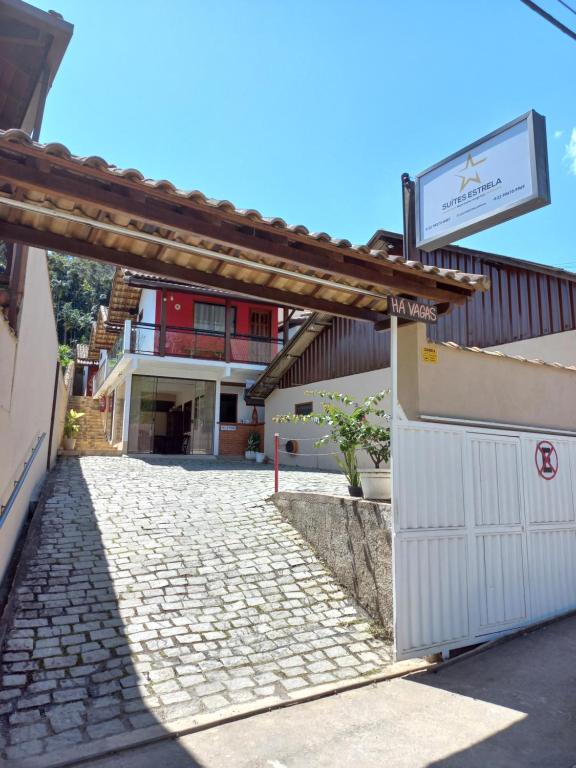 uma entrada para um edifício com uma placa em Suites Estrela em São Pedro da Serra