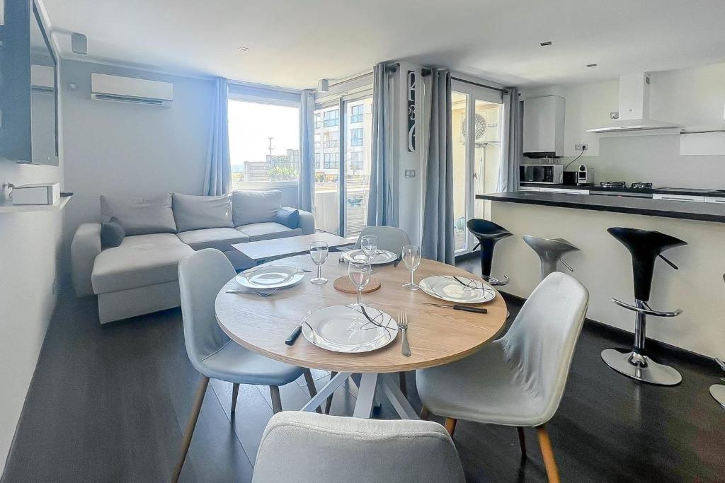 une table à manger et des chaises dans un salon dans l'établissement CLOSE SEA - Terrace with Sea View AC and Parking - BENAKEY, à Cannes