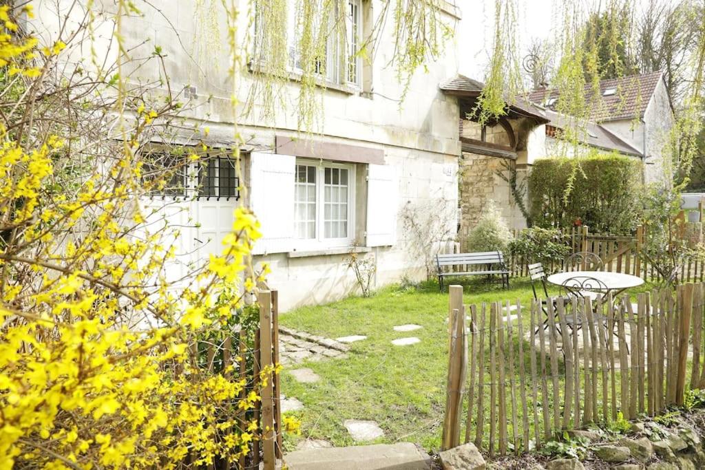 una casa con una valla y una mesa en el patio en Appartement Le Moulin by La Boîte En Plus, en Senlis