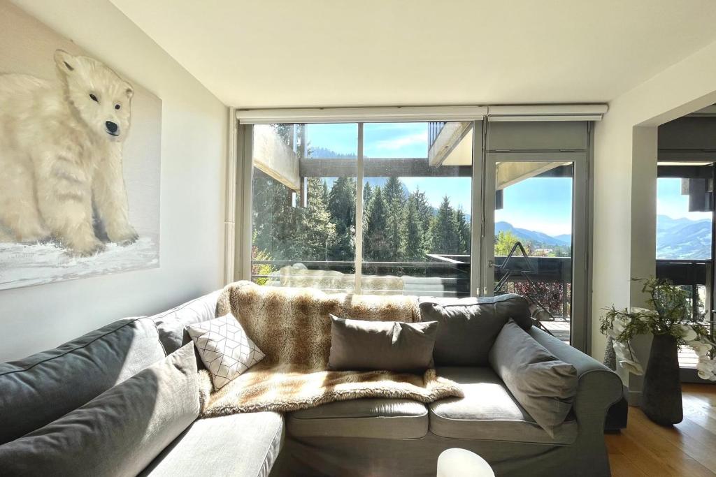 a living room with a couch and a large window at Beautiful 50m with a superb view of Megève in Megève