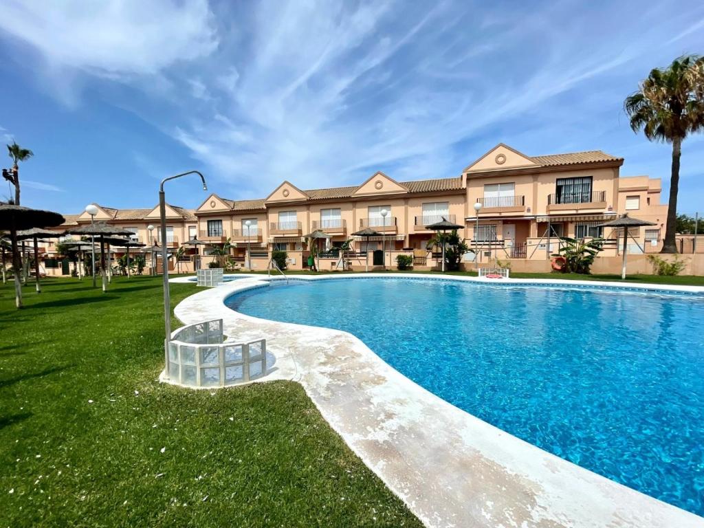 una piscina frente a un edificio en Apartamento Rocio Al-Andalus, en Chiclana de la Frontera