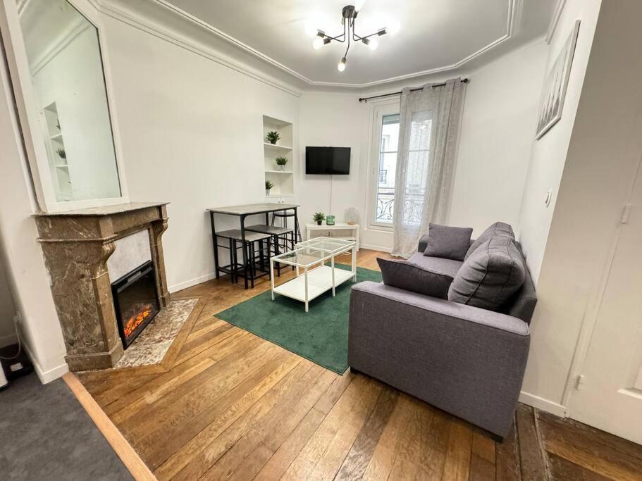 a living room with a couch and a fireplace at Magnifique Appartement - Mairie 18ème in Paris