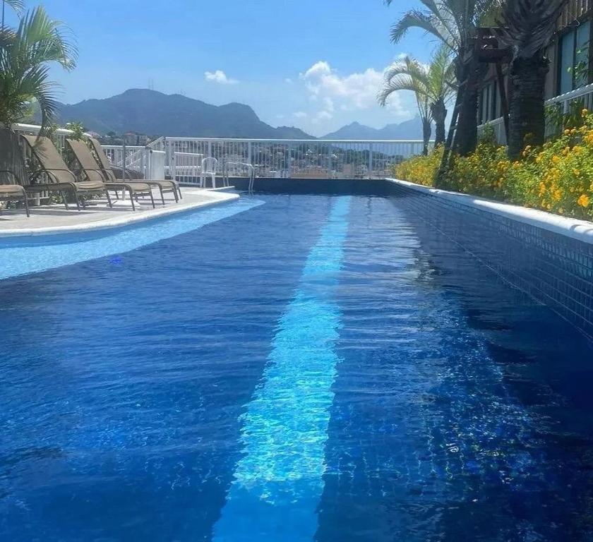 een zwembad met blauw water in een resort bij Lapinha 40 Graus Studio in Rio de Janeiro