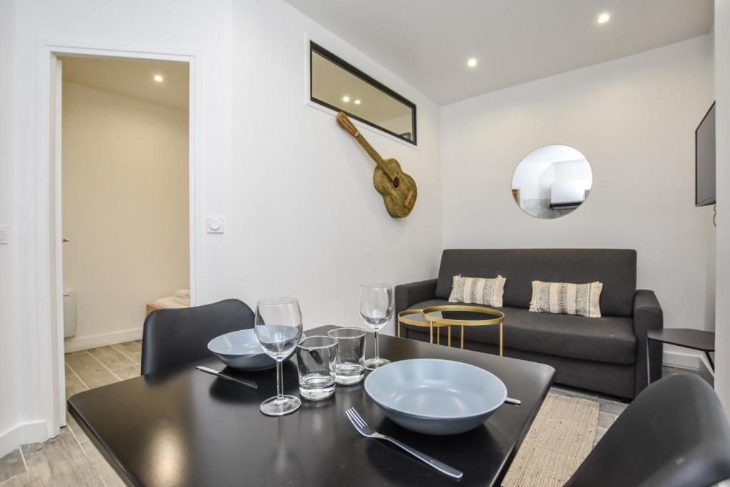 - un salon avec une table, des verres à vin et un canapé dans l'établissement Cosy apartment - 1BR-4P - Auteuil, à Paris