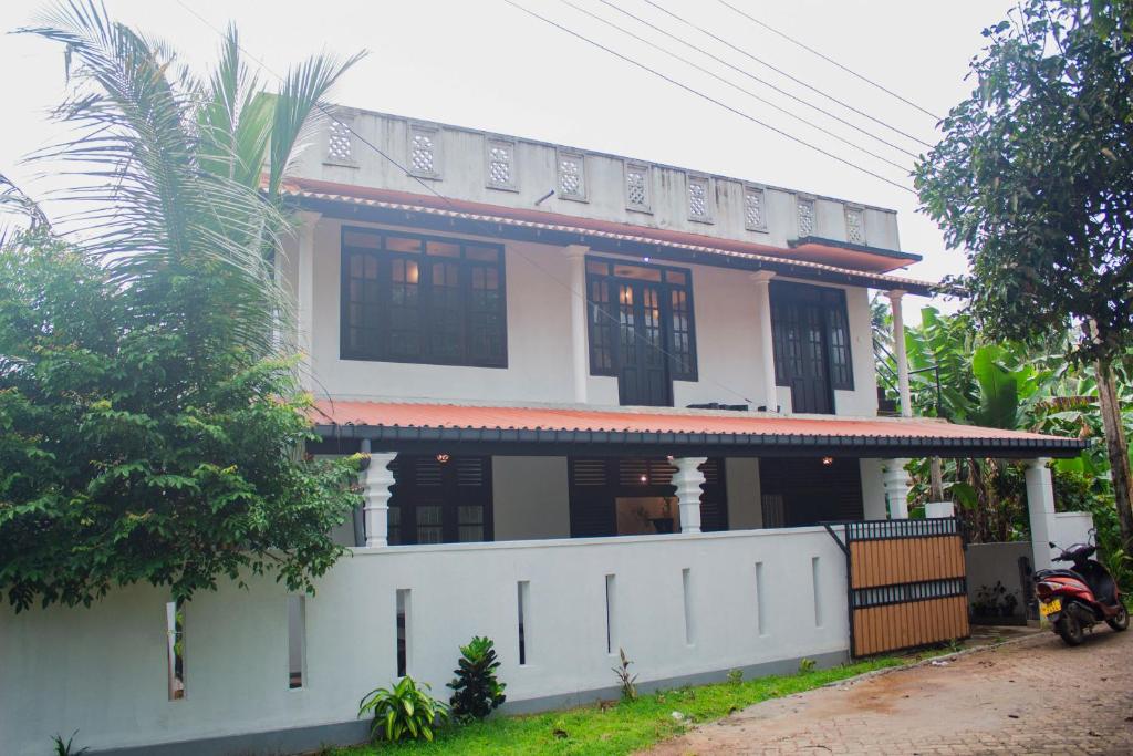 una casa con una cerca blanca delante de ella en Cliff house en Weligama