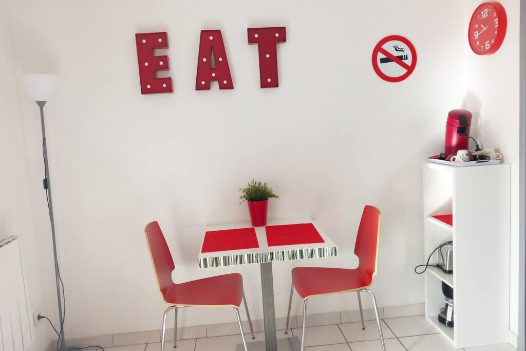 - une salle à manger avec une table, des chaises et un clavier dans l'établissement studio costieres climatisé parking gratuit lave linge loggia, à Nîmes