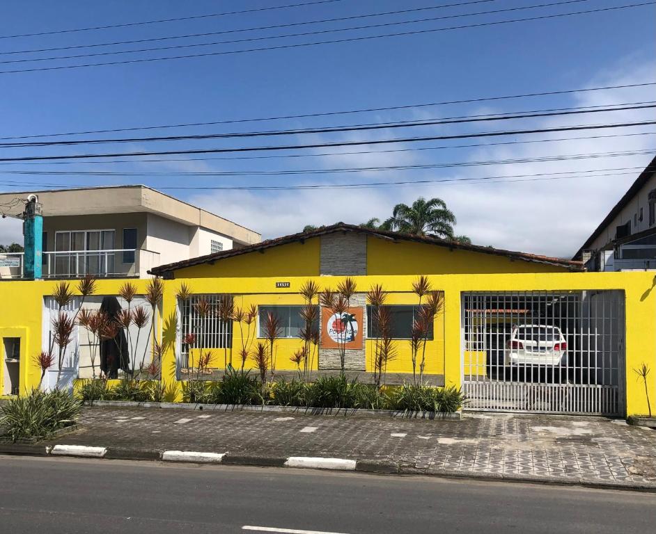 ein gelbes Gebäude an der Straßenseite in der Unterkunft Pousada Beira-mar I in Bertioga