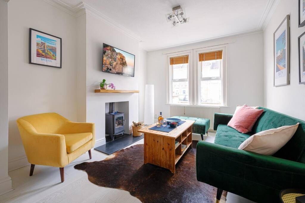 a living room with a green couch and a chair at Pure B - Welcoming Bath City 3 Bed House Free Parking & Wifi in Bath