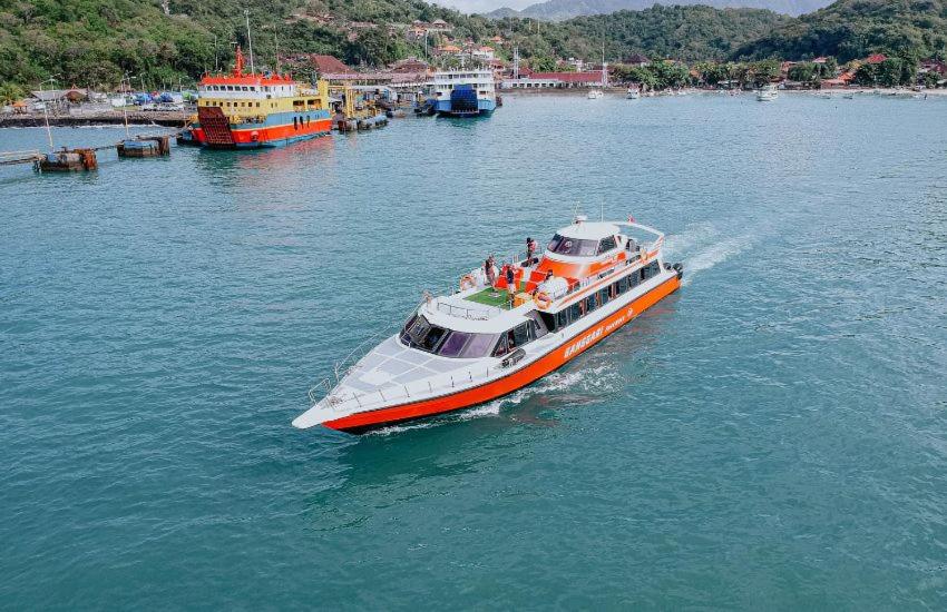 an orange and white boat in the water at Gili Ferries Ganggari Speedboat in Padangbai