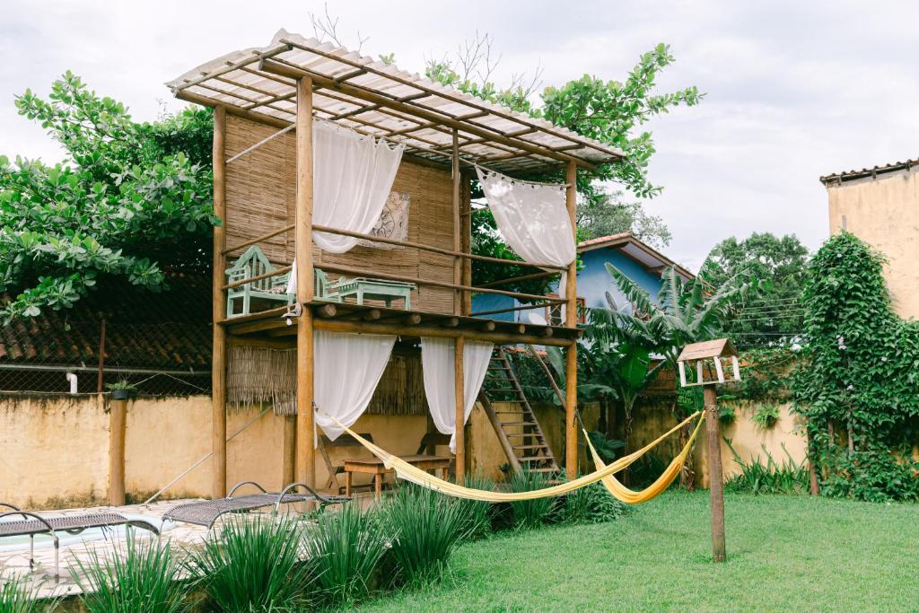 a tree house with a hammock in a yard at Recanto Sole Luna in Maresias