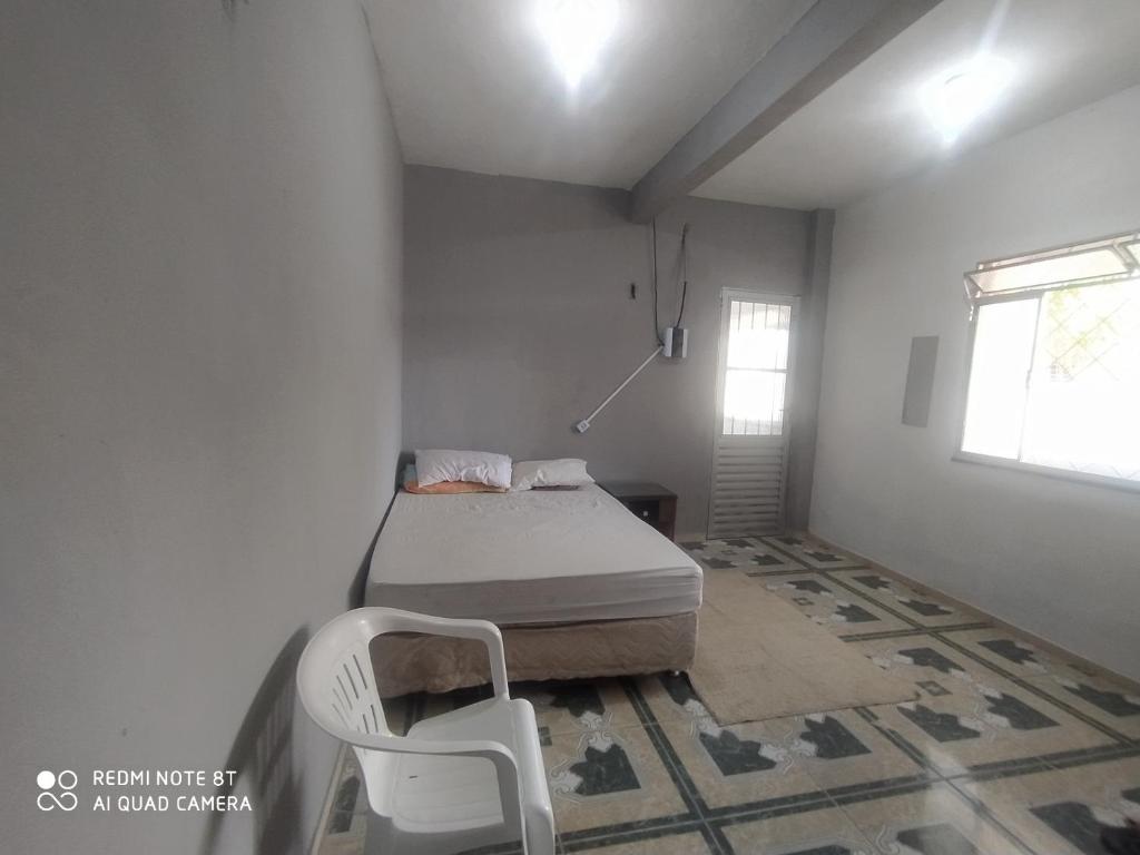 a bedroom with a bed and a chair in it at Casa Ariramba Mosqueiro in Belém