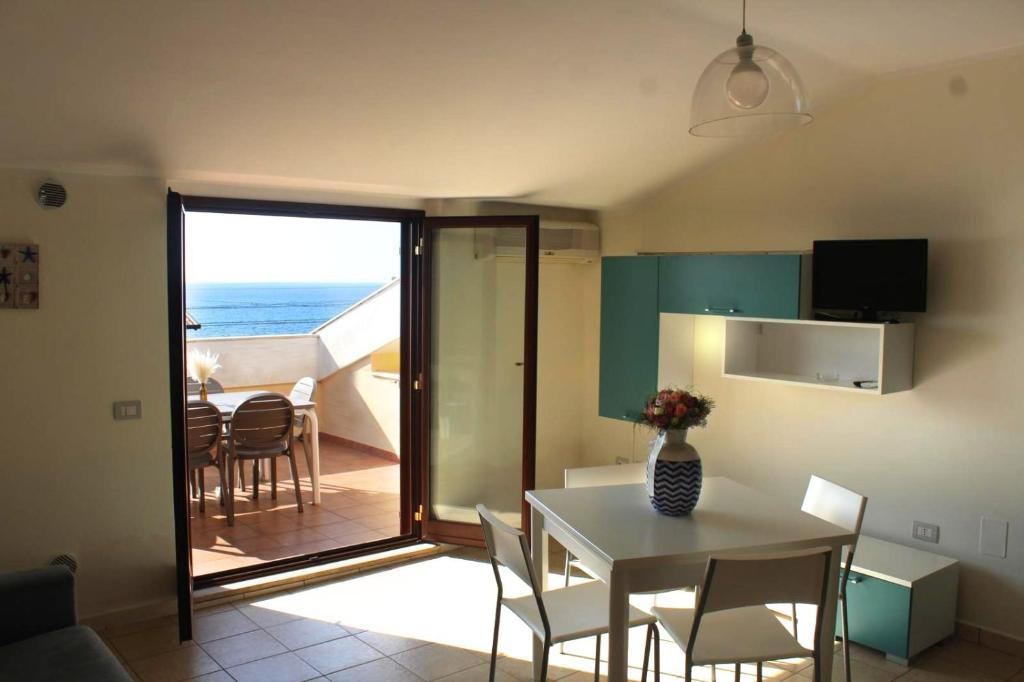 a kitchen and dining room with a table and a view of the ocean at Il Borgo della Marinella Case Vacanze in Amantea